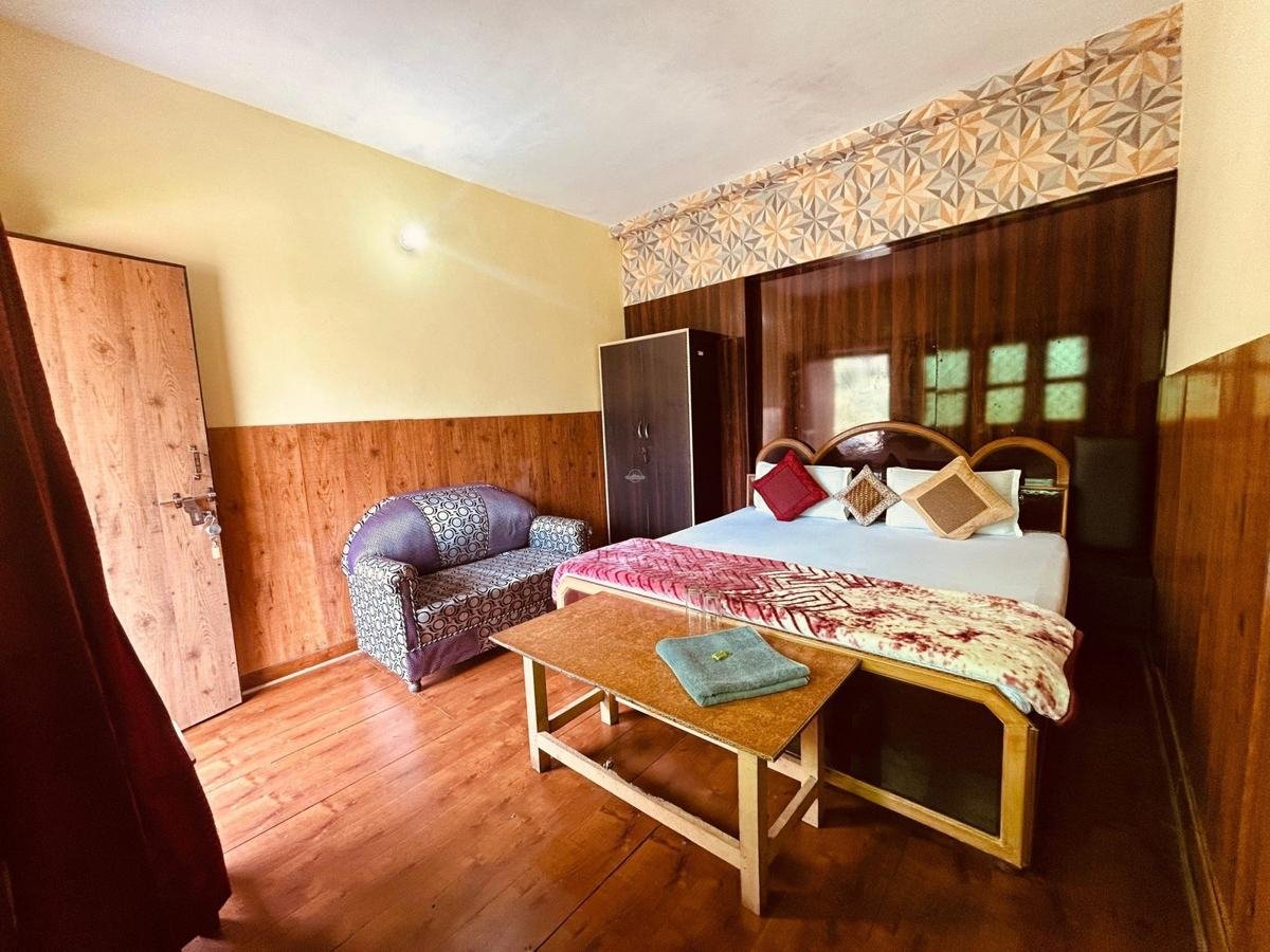 Room with double bed and bench